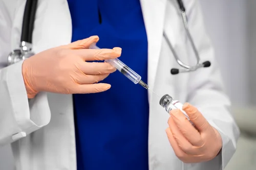 Доктор набирает шприц для кодировки уколом от алкоголизма